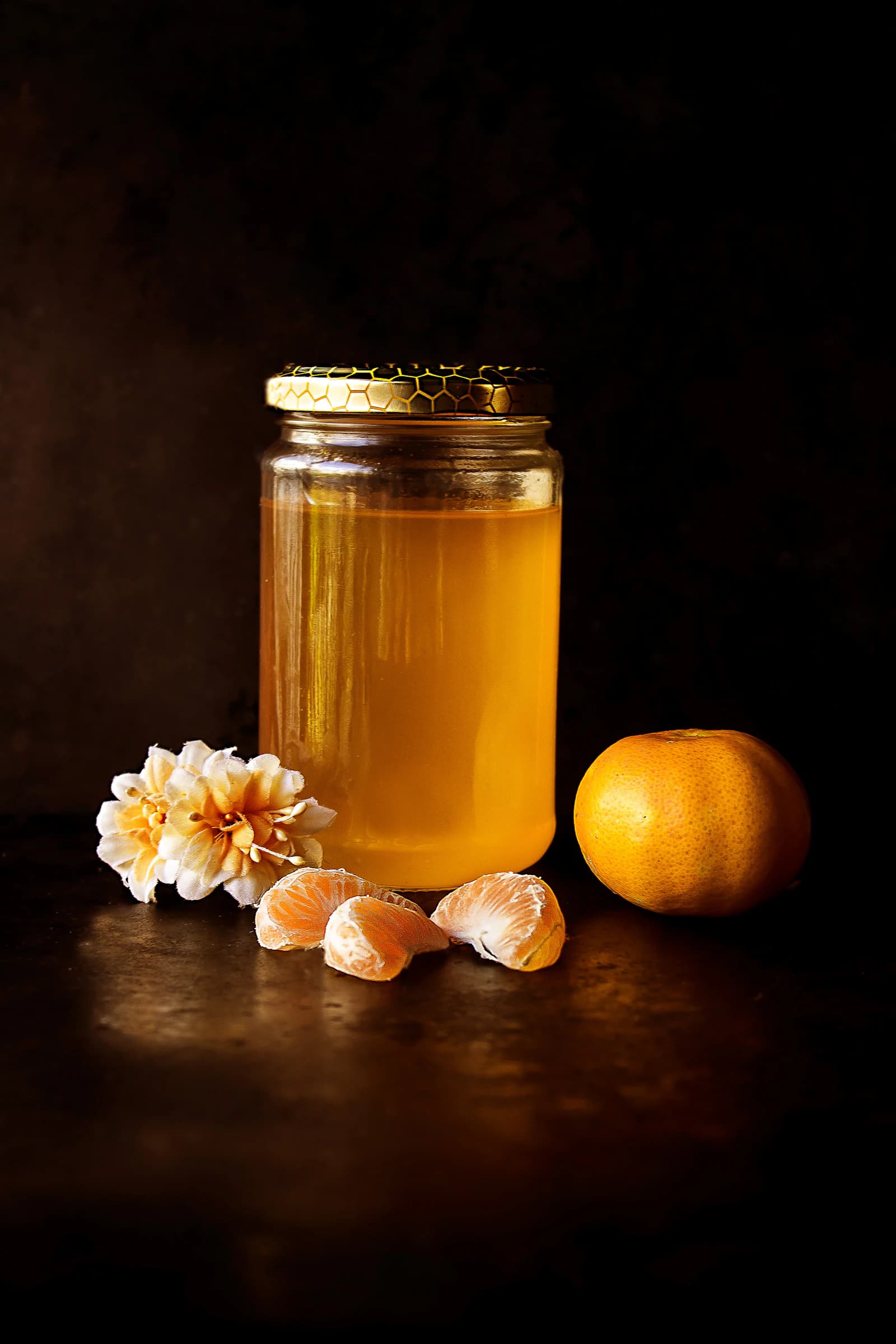 A jar of golden honey on a dark table
