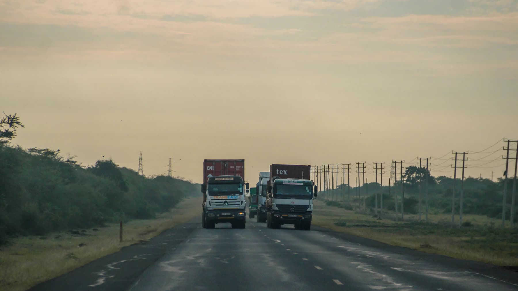 Loaded trucks on an East African highway at first light