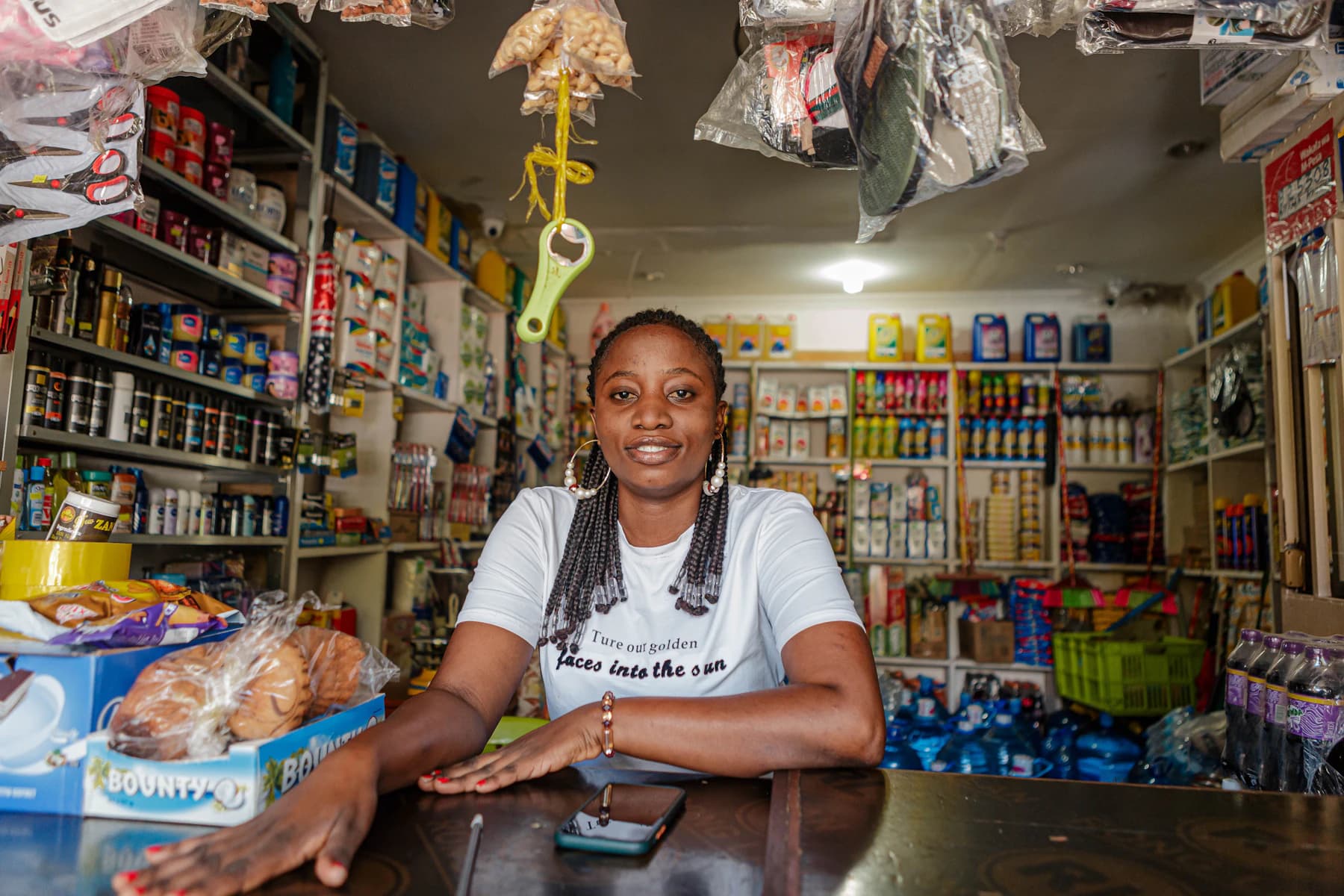 A shopkeeper at the counter of her well-stocked shop