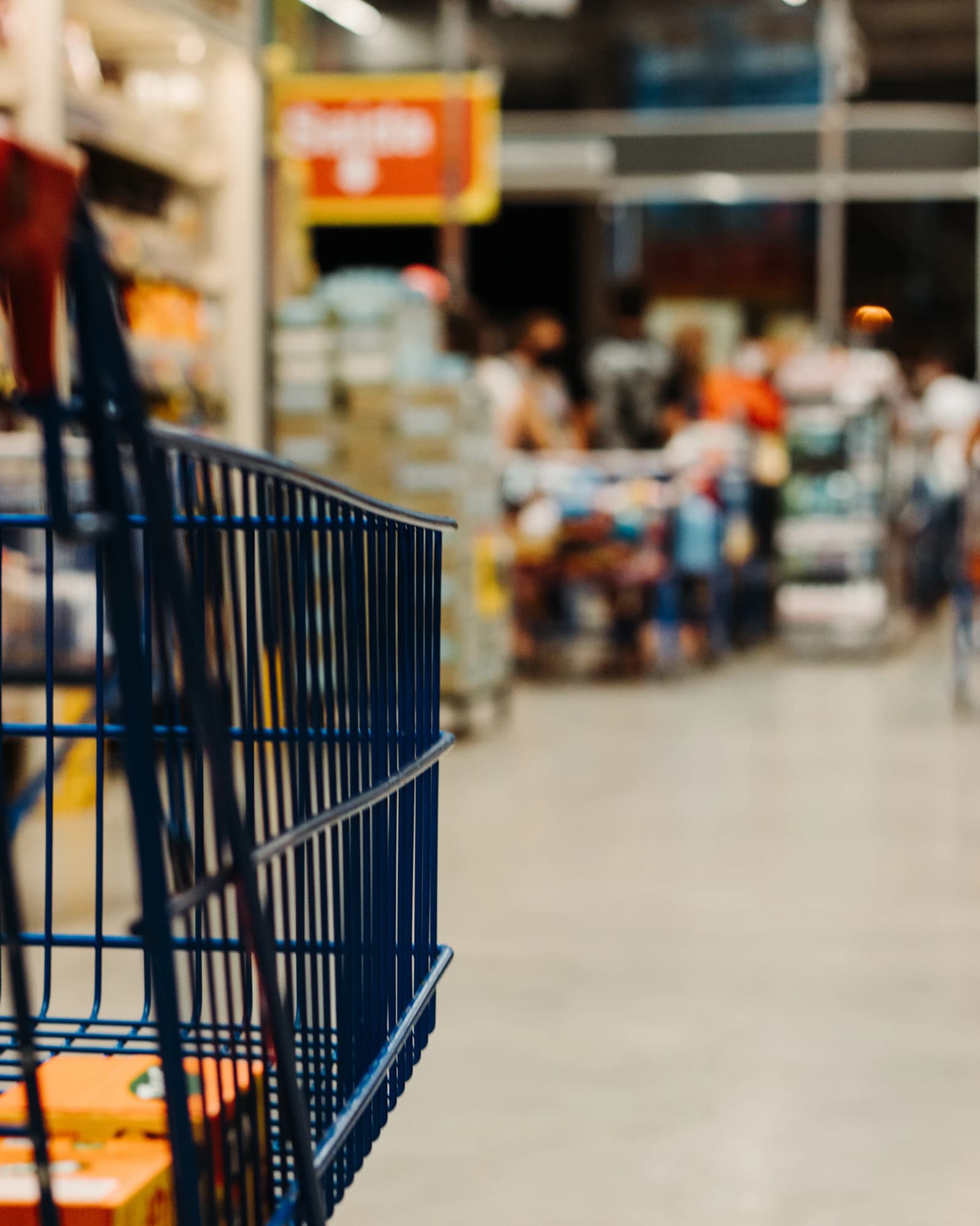 A shopping basket in a busy retail aisle