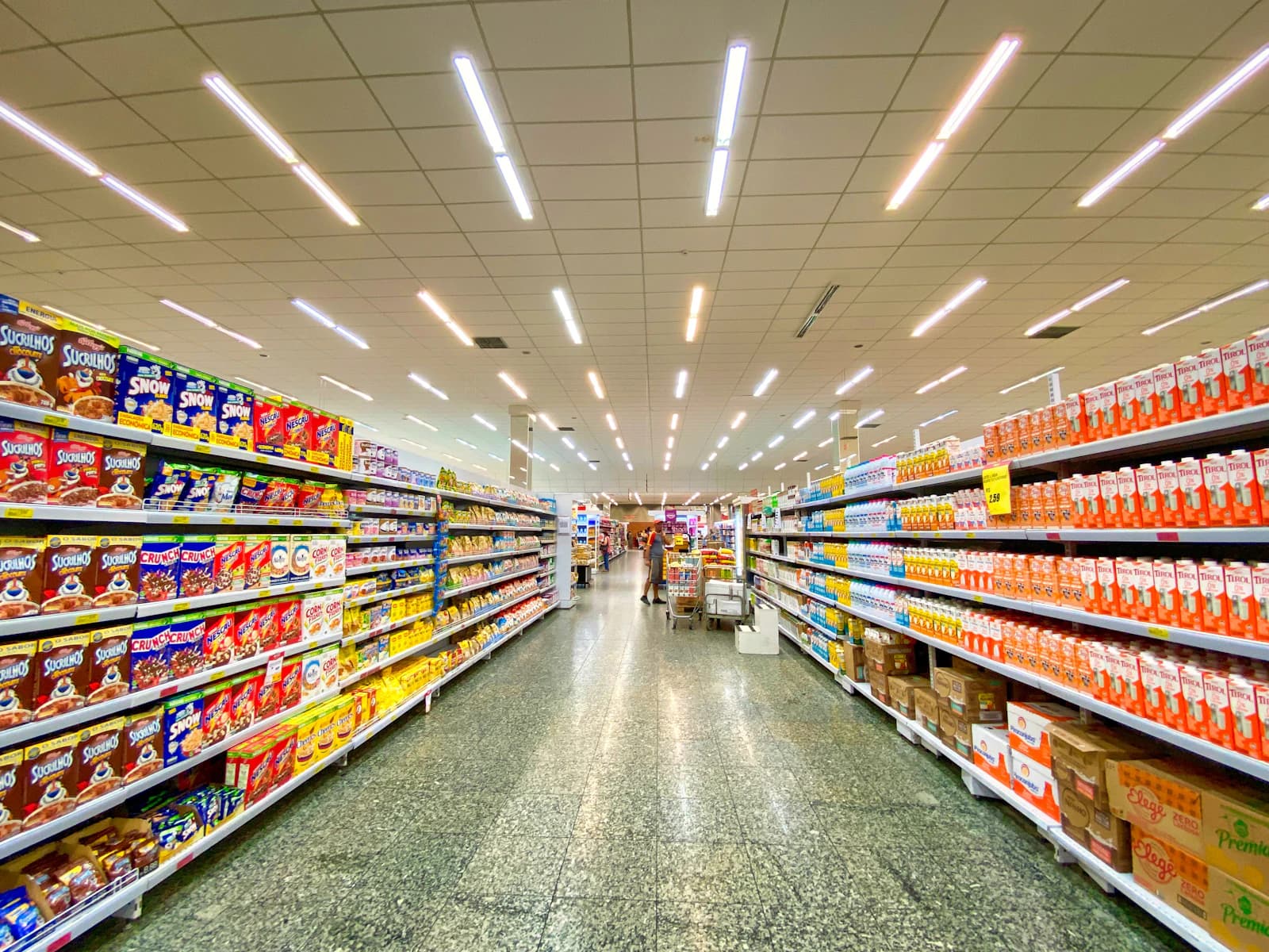 A long, fully stocked supermarket aisle